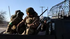 Трое украинских военных с оружием сидят в кузове пикапа