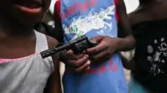 Niños sostienen una pistola de juguete en Buenaventura, Colombia, en 2021.