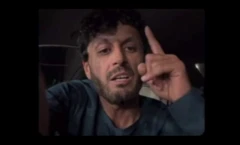 داوود الکوزی، شهروند افغانستان درحالی که انگشتش را بالا برده با پیراهن مشکلی دیده می‌شود. 