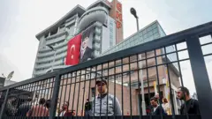 CHP genel merkezi önünde toplanmış insanlar ve üniformalı bir güvenlik görevlisi