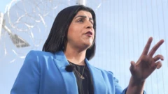 Министр юстиции Шабана Махмуд выступает на фоне забора из колючей проволоки