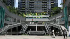 Pessoas caminham em frente ao edifício Prince International Plaza em Phnom Penh, no dia 15 de outubro de 2025