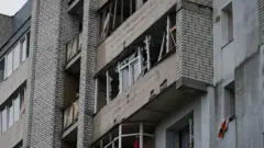 Будинок з вибитими вікнами після обстрілу