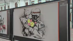 Участник российского вторжения держит ребенка на руках