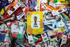 Álbum da Copa do Mundo ao meio com várias figurinhas de jogadores ao redor