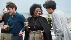 맥주병과 와인잔 등을 들고 동료와 이야기를 나누는 모습