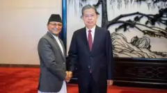 ন্যাশনাল পিপলস কংগ্রেসের স্থায়ী কমিটির চেয়ারম্যান ঝাও লে জি (ডানে), নেপালের জাতীয় এসেম্বলির স্পিকার গণেশ প্রসাদ তিমিলসিনা (বাঁয়ে)