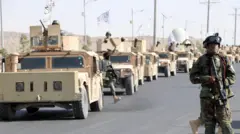 یک نیروی طالبان با تفنگ امریکایی در رژه با تجهیزات آمریکایی در قندهار مقر رهبری طالبان