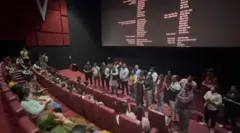 सिनेमा हॉल में शपथ दिलाते लोग