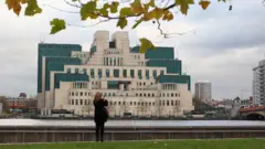 Mulher fotografa o edifício do serviço de inteligência britânico em Londres.