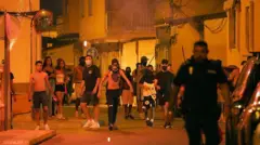 Vários jovens cobrem o rosto durante os distúrbios de Torre Pacheco.