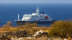 O navio de cruzeiro holandês MV Hondius (ao fundo) está ancorado ao largo da cidade da Praia, na ilha de Santiago, em Cabo Verde