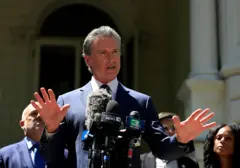El gobernador de California, Gavin Newsom, habla con las manos abiertas y las palmas hacia abajo en una conferencia de prensa en apoyo de los demócratas de Texas.
