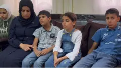 إخلاص صالح مع أبنائها ألأربعة في منزلهم ببلدة الساوية
