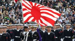 日本海上自卫队旗帜于2018年10月14日在埼玉县朝霞市的陆上自卫队朝霞训练场举行的阅兵检阅中可见。约4,000名人员、260辆车辆和40架飞机参加了这次军事阅兵。