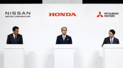 Макото Учида, глава Nissan Motor Corporation, Тосихиро Мибе, глава Honda, и Такао Като, глава Mitsubishi Motors, проводят совместную пресс-конференцию
