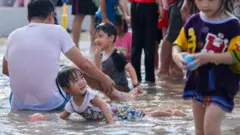 台湾家长陪同小孩在酷热天气中玩耍