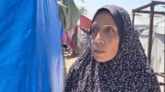 سيدة نازحة في أحد المخيمات تتطلع إلى يمينها وفي عينيها حزن عميق