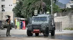 شاب فلسطيني يرفع قميصه أمام الجيش الإسرائيلي ليؤكد أنه ليس مسلحا 