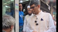 সুপ্রিম কোর্টের জামায়াতপন্থী আইনজীবী এ এস এম শাহরিয়ার কবিরের একজন পান-সিগারেট বিক্রেতার হাতে এক হাজার টাকার নোট গুঁজে দিচ্ছেন। 