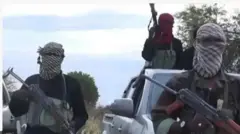 Aworan awon agebbọn to gbe ibọn dani, bomu.Awọn kan duro ninu ọkọ, awọn kan si duro siwaju ọkọ.