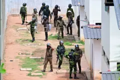 Sri Lanka Special Task Force (STF) and police personnel patrol during a riot at the Pallansena open prison on August 7, 2026 amid a stand-off between inmates and their guards.