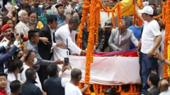 सुवास नेम्वाङको शवमा राष्ट्रिय झण्डा ओढाउँदै प्रधानमन्त्री पुष्पकमल दाहाल 