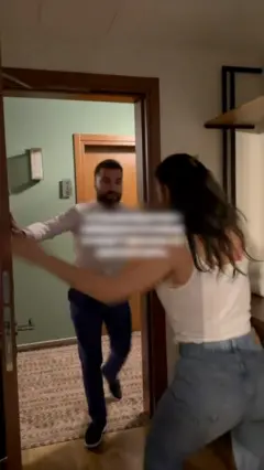 Девушка держит рукой дверь, в которую пытается прорваться мужчина.
