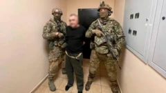 軍服を着た2人の武装した人々は、マスクを閉じて黒い衣服で拘留し、その顔が洗っています