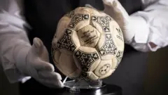 Muškarac sa belim rukavicama oko lopte kojom je Maradona postigao čuveni gol „božija ruka"