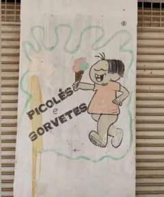 Pintura à mão da Mônica segurando um sorvete ao lado da inscrição "Picolés e sorvetes"