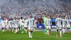Messi wit oda players for pitch wit crowd for back