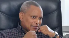 ኣብ መንበሩ ኮፊ ኢሉ ናይ ጉስጢ ምልክት እናርኣየ ዝዛረብ ደብረጽዮን ገብረሚካኤል