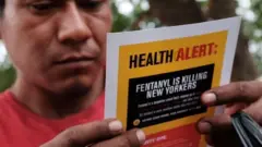 ਸਿੰਥੈਟਿਕ ਡਰੱਗਜ਼ ਬਾਰੇ ਚੇਤਾਵਨੀ ਇਸ਼ਤਿਹਾਰ ਪੜ੍ਹ ਰਿਹਾ ਵਿਅਕਤੀ