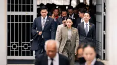 ปิฎก สุขสวัสดิ์ สามีของแพทองธาร ถือสูทของพ่อตาเอาไว้ในมือขณะเดินออกจากศาลฎีกาฯ เม่อ 9 ก.ย.