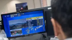 Un hombre mira las notcias sobre el terremoto en su computadora