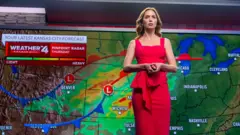 Emily Blunt aparece frente a un mapa del clima en El día de la revelación