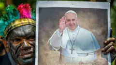 Laki-laki asli Papua memegang foto Paus Fransiskus di depan Kedutaan Besar Vatikan 