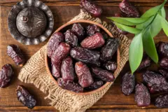 Dattes medjool séchées dans un bol sur fond de bois.