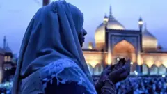 Wata mace tana addu'a kusa da wani masallaci