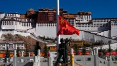 Uma bandeira chinesa hasteada em frente ao Palácio de Potala, em Lhasa