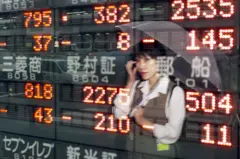 Reflexo de mulher com guarda-chuva em telão com números