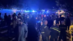 يتجمع الناس وأفراد الدفاع المدني عند مدخل مخيم عين الحلوة للاجئين الفلسطينيين، بعد غارة إسرائيلية أسفرت عن مقتل عدة أشخاص، وفقًا لوزارة الصحة اللبنانية، في مدينة صيدا الجنوبية، لبنان