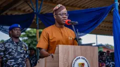 Seyi Makinde wọ aṣọ alawọ paali, gbohungbohun wa niwaju rẹ