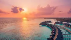 Sunset in the Maldives. Horizon with colored clouds on the sea and the dock of the Aquatic Villa.