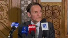 نمایندهٔ ویژهٔ بریتانیا برای افغانستان. مردی که دریشی به تن دارد و نکتایی زده