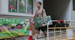 Dorz Cheung, a resident of Wang Fuk Court, carries family belongings, which he retrieved from his flat during his first return visit home since a deadly fire last year, in Hong Kong, China, April 21, 2026.