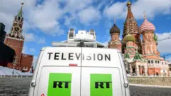 Van de transmissão da TV Russia Today (RT), controlada pelo Estado russo, estacionada em frente à Catedral de São Basílio e ao Kremlin, perto da Praça Vermelha, em Moscou