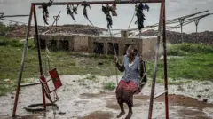 Wata ƴar gudun hijira ta ƙasar Congo na wasa cikin ruwan sama a sansanin Cishemere da ke kusa da Buganda, ranar 6 ga watan Mayun 2025