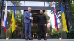 Зеленський та Фіцо тиснуть руки, біля них - прапори України та Словаччини з обох боків